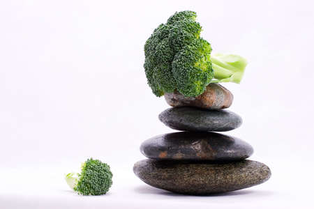 Peace of broccoli on the top of zen stones pyramid in balanceの写真素材