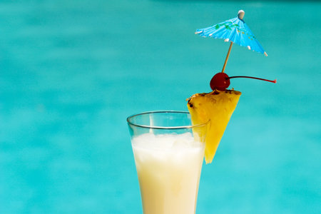 Glass of Pina Colada cocktail on swimming pool sideの写真素材