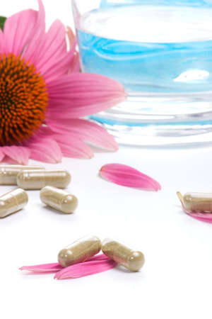 Closeup of Echinacea extract pills, fresh Echinacea flowers and glass of water best suited for alternative medicine ads. Shalow DOF.の写真素材