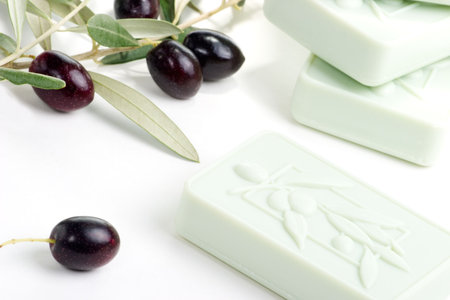 Spa set - fresh black olives, oils, organic soap and towels over white background best suited for relaxing and health commercialsの写真素材