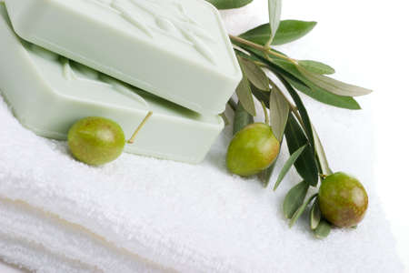 Spa set - fresh green olives, oils, organic soap and towels over white towel. best suited for relaxing and health commercialsの写真素材