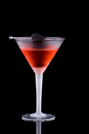 Martini in chilled glass over black background on reflection surface. Red color, made with blackberry liqueur and garnished with freah blackberry. Most popular cocktails series.の写真素材