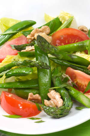 Closeup of plate of asparagus, snow pea and tomato salad with ginger dressing. の写真素材