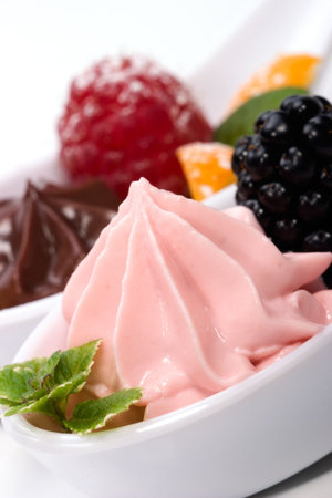 Closeup of a la carte spoon filled with delicious strawberry souffle  served with fresh blackberry...