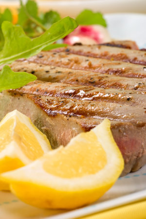 Closeup of juicy delicious Citrus-peppercorn-spiked grilled tuna steak with grilled vegetables. Shallow DOFの写真素材