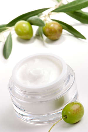 Closeup of jar of moisturizing face cream and twig with green olives.の写真素材