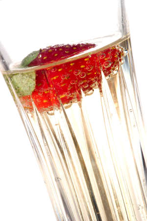 Closeup of glass of Champagne with strawberry in it over white background. Studio isolated.の写真素材