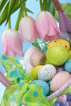 Closeup of basket of easter eggs and pink tulips