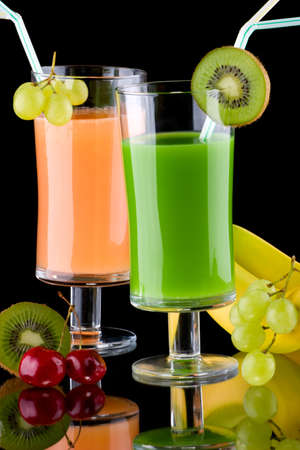 Two glasses of organic juice made from fresh fruits and surrounded by fresh ones. Series about organic and healthy drinks.の写真素材