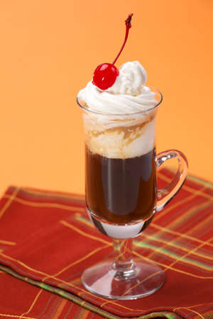 Closeup of tasty B-52 Coffee Cocktail, Baileys, Grand Marnier, Kahlua, coffee, whipped cream and maraschino cherry - Coffee Warmers seriesの写真素材