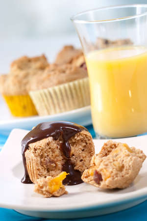 Whole grain muffins with chocolate sauce. Glass of orange juice.の写真素材