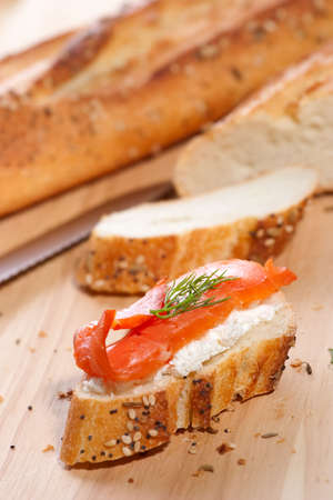 Closeup of delicious canape with smoked salmon, cream cheese spread and dill on holiday tableの写真素材