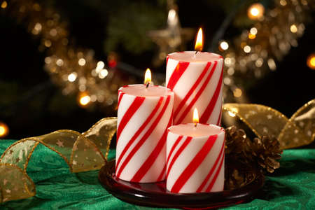Closeup of peppermint candles, flutes of champaine champagne and Christmas tree with lights out of focus in background. の写真素材