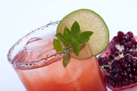 Closeup of Pomegranate Mojito and broken open pomegranate over white.の写真素材