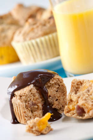 Whole grain muffins with chocolate sauce. Glass of orange juice.の写真素材
