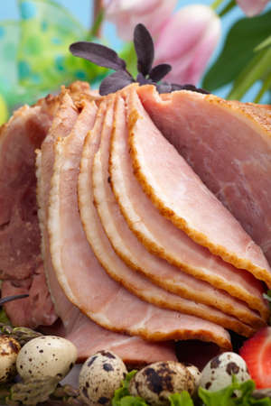 Honey ham on Easter table with quail eggs, tulips and decoration
の写真素材