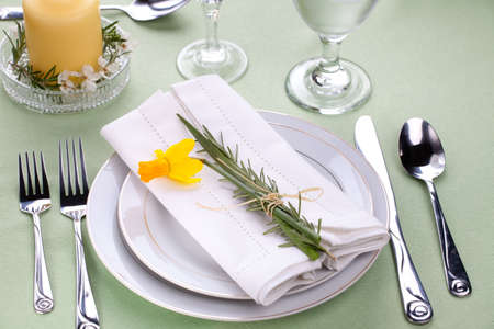 Daffodil table settings. Arrangements with yellow daffodil and fresh rosemaryの写真素材