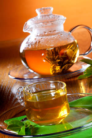 Glass of greean tea and teapot with Chinese green tea. Jasmine flower inside.の写真素材