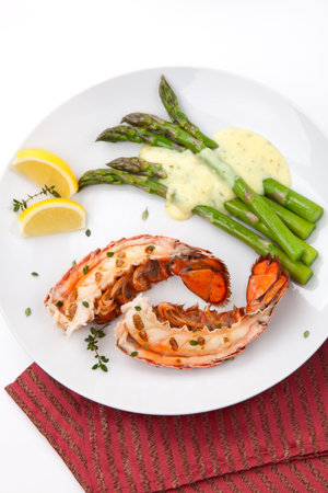 Closeup of delicious grilled lobster tails served with asparagus and bearnaise sauceの写真素材