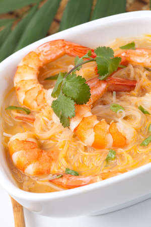 Closeup of bowl of Prawn Laksa soup with rice noodles, shrimps garnished with fresh cilantro.の写真素材
