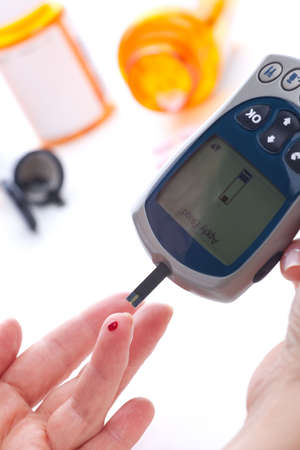Diabetic is doing a glucose level finger blood testの写真素材