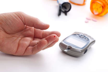 Diabetic is doing a glucose level finger blood testの写真素材
