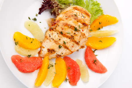 Grilled chicken breast with citrus salad - pink grapefruit, lime, orange, lettuce and fresh thyme.の写真素材