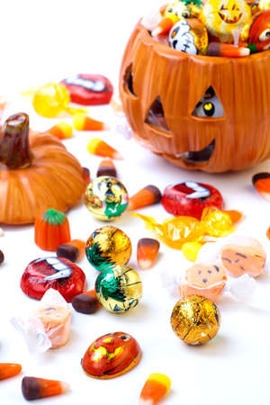Scatter Halloween candies and orange pumpkin filled by themの写真素材