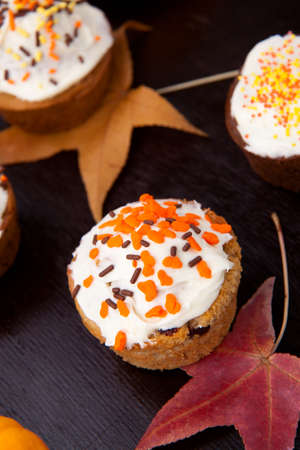 Full plate of just baked whole grain home made muffins in fall environment.の写真素材