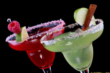Apple and Raspberry margaritas in chilled glass over black background on reflection surface, garnished slice of green apple, fresh raspberries, slice of lime and cinnamon stick. Most popular cocktails series.の写真素材