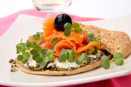 Closeup of delicious open-face sandwich with smoked salmon, goat cheese and daikon sprouts.の写真素材