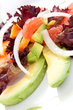 Closeup of papaya, avocado and grapefruit salad with sweet onion and lime wedgesの写真素材