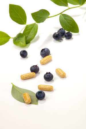 Bilberry extract pills and fresh berries and leaves best suited for alternative medicine adsの写真素材