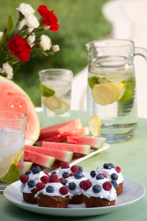 Muffins, fruits and cold drinks on picnic tableの写真素材