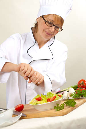 Executive chef preparing fresh organic salad, pouring dressingの写真素材