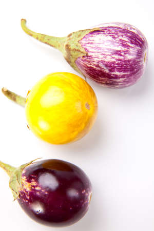 Fresh multi colored mini eggplants in rowの写真素材