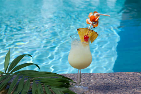 Glass of Pina Colada cocktail on swimming pool sideの写真素材