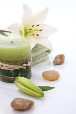 Aromatherapy lily spa set -  lily flowers, aroma candle, spa stones and and towels over white background best suited for relaxing and health commercialsの写真素材