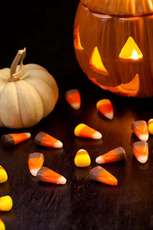Scatter Halloween candies and orange pumpkin with lightの写真素材