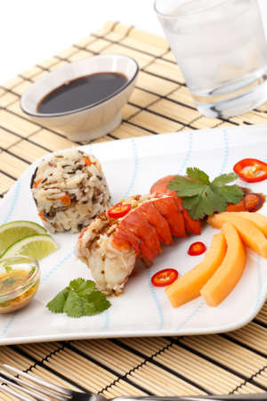 Closeup of delicious lobster tails served with spicy sauce, rice and melonの写真素材