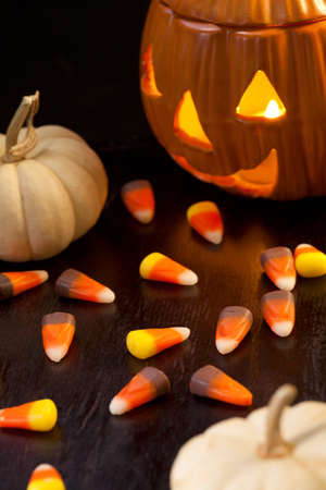 Scatter Halloween candies and orange pumpkin with lightの写真素材
