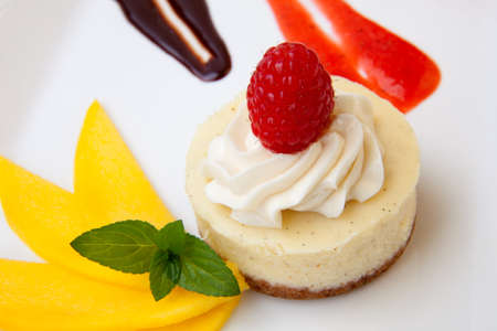 Delicious Vanilla Raspberry Cheesecake served with fresh mango and mint.の写真素材