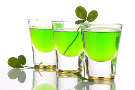 Row of green liquor shots for St Patrick's Day and clover leafs.の写真素材