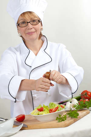 Executive chef preparing fresh organic salad, pouring dressingの写真素材