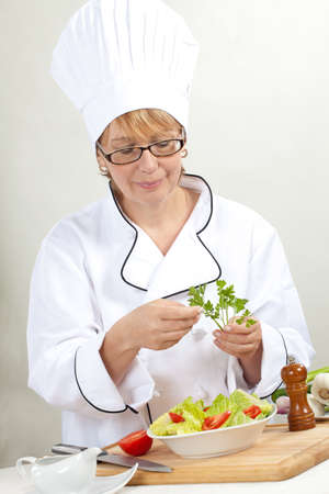 Executive chef preparing fresh organic salad, pouring dressingの写真素材
