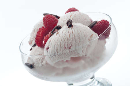 Closeup of delicious Fruit Ice Cream with fresh raspberries and chocolate swirls.の写真素材