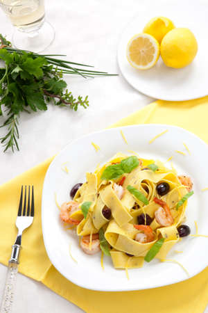 Shrimp lemon pepper Pappardelle pasta with frsh basil, and black olives.の写真素材