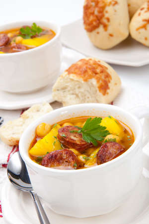Two bowls of hot fresh golden chorizo and chickpea soup and cheese garlic bunsの写真素材