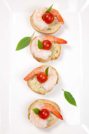 Closeup of delicious Shrimp Canape with cherry tomatoes, basil and wasabi spread.の写真素材