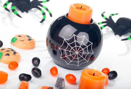 Halloween candy scattered around, candles, and spiders.の写真素材
